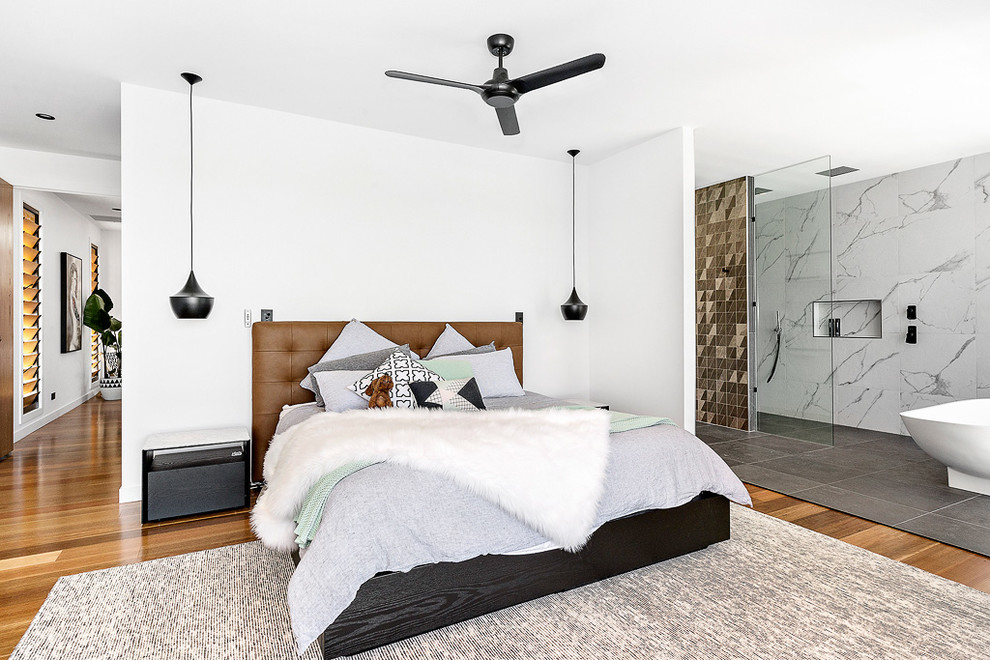 Example of a mid-sized trendy master medium tone wood floor bedroom design in Brisbane with white walls