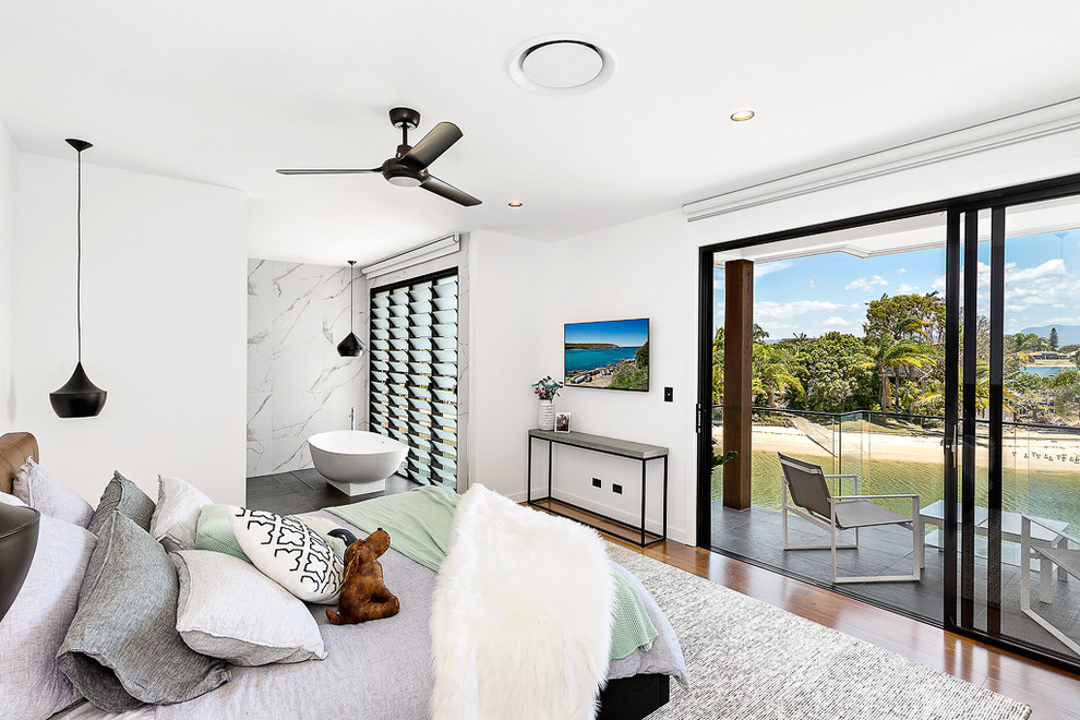 Mid-sized trendy master medium tone wood floor bedroom photo in Brisbane with white walls