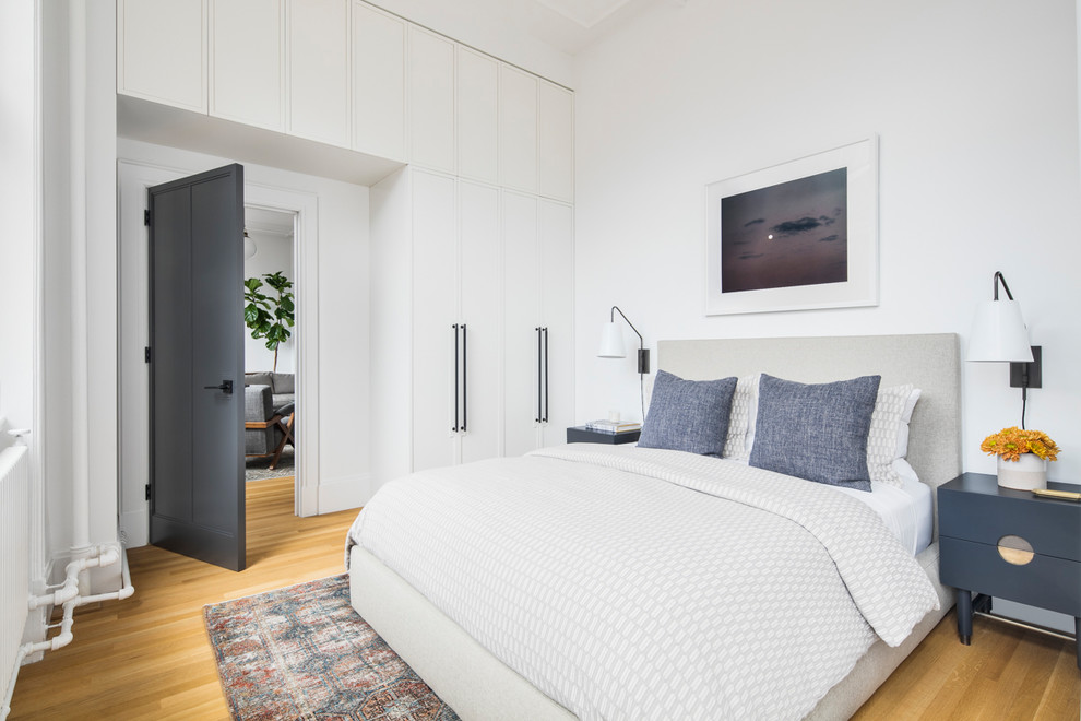 Diseño de habitación de invitados clásica renovada con paredes blancas, suelo de madera clara y suelo beige