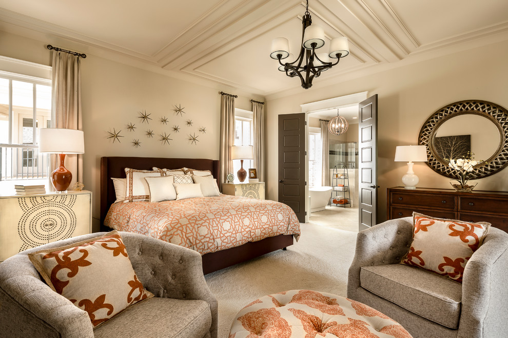 Imagen de dormitorio principal clásico renovado grande con paredes beige, moqueta, chimenea de esquina y marco de chimenea de piedra