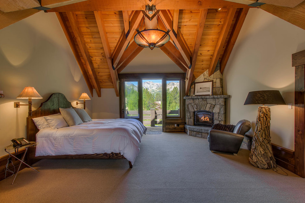 Design ideas for an expansive rustic bedroom in Sacramento with white walls, carpet, a corner fireplace, a stone fireplace surround and beige floors.
