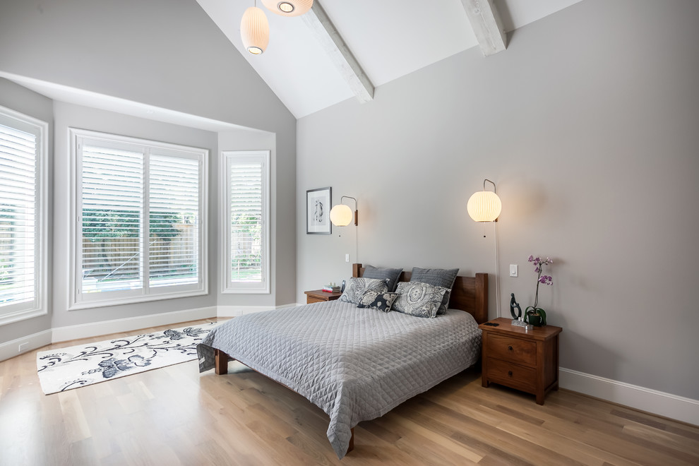 Diseño de dormitorio principal escandinavo grande con paredes grises y suelo de madera clara