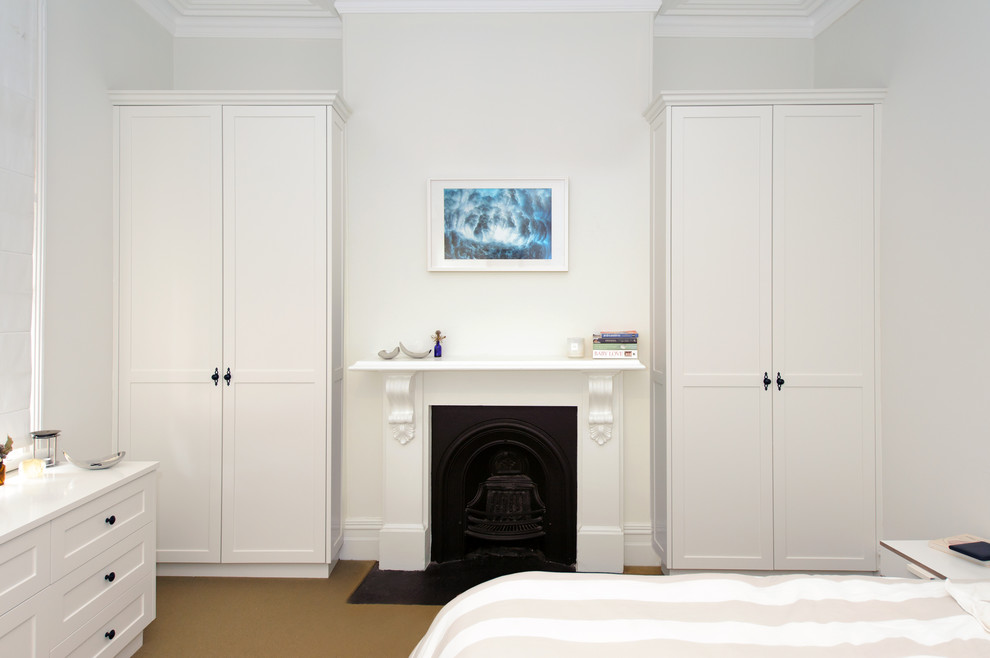 シドニーにある小さなトランジショナルスタイルのおしゃれな主寝室 (白い壁、カーペット敷き、標準型暖炉、木材の暖炉まわり) のレイアウト