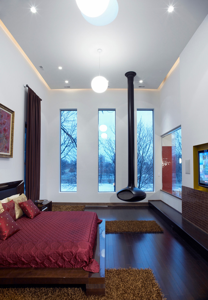 Geräumiges Modernes Schlafzimmer im Loft-Style mit beiger Wandfarbe, dunklem Holzboden und Hängekamin in Chicago