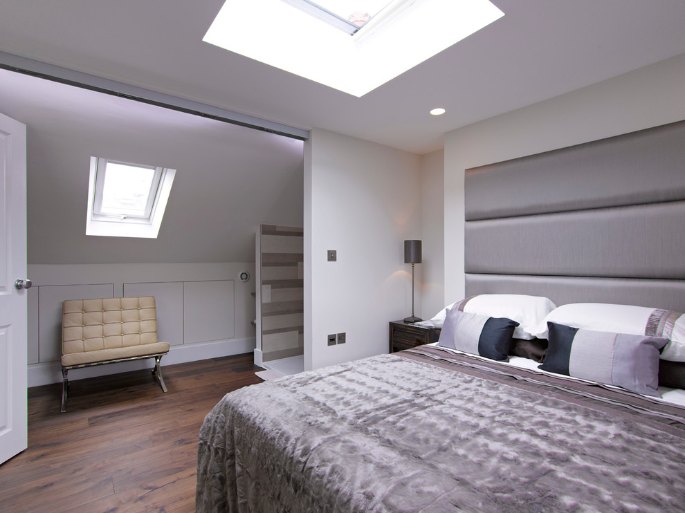 Modern inredning av ett sovrum, med vita väggar och mörkt trägolv