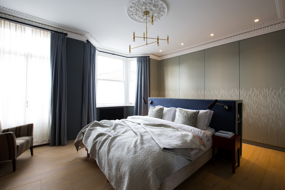 Geräumiges Skandinavisches Hauptschlafzimmer mit grüner Wandfarbe und braunem Holzboden