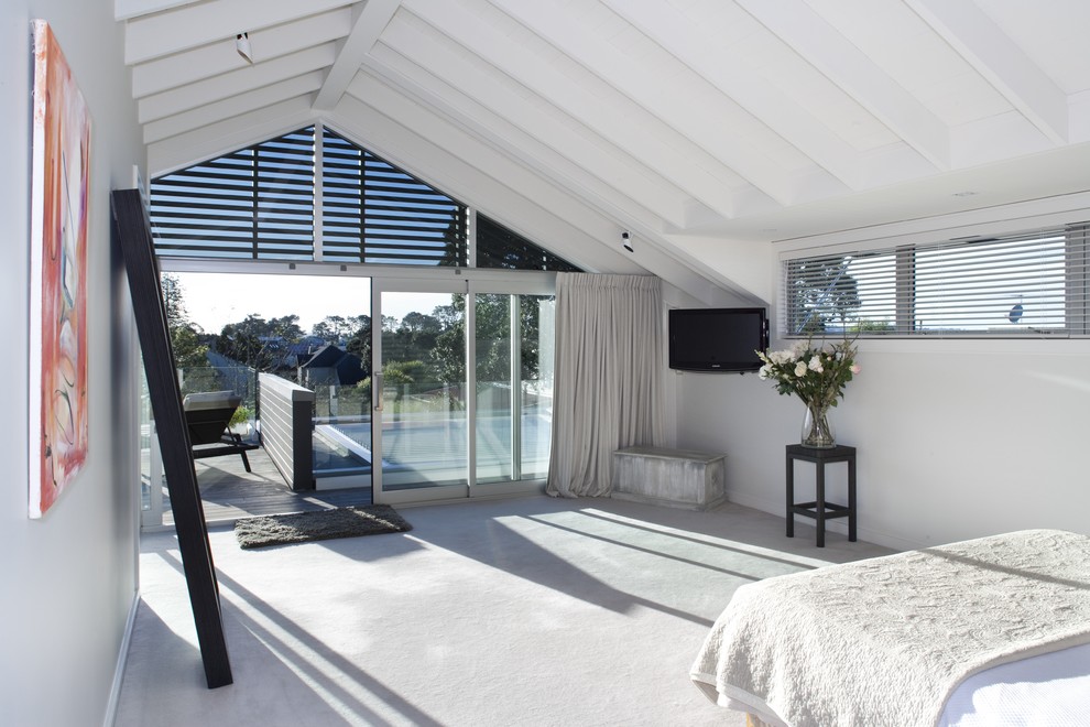 Contemporary bedroom in Auckland with white walls and carpet.