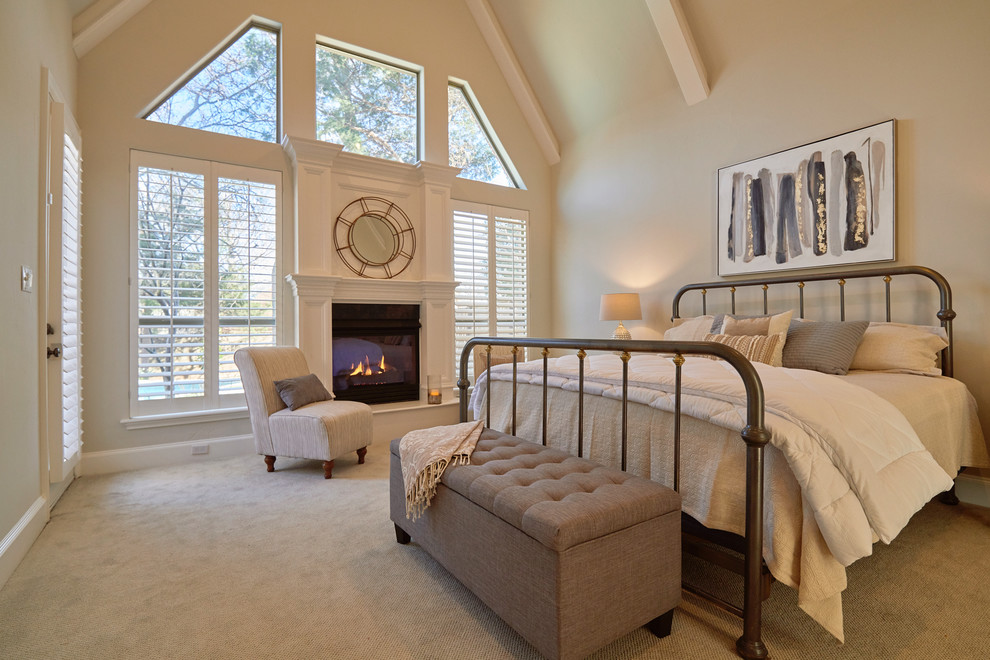 Идея дизайна: большая хозяйская спальня в стиле неоклассика (современная классика) с серыми стенами, ковровым покрытием, стандартным камином, фасадом камина из дерева и бежевым полом