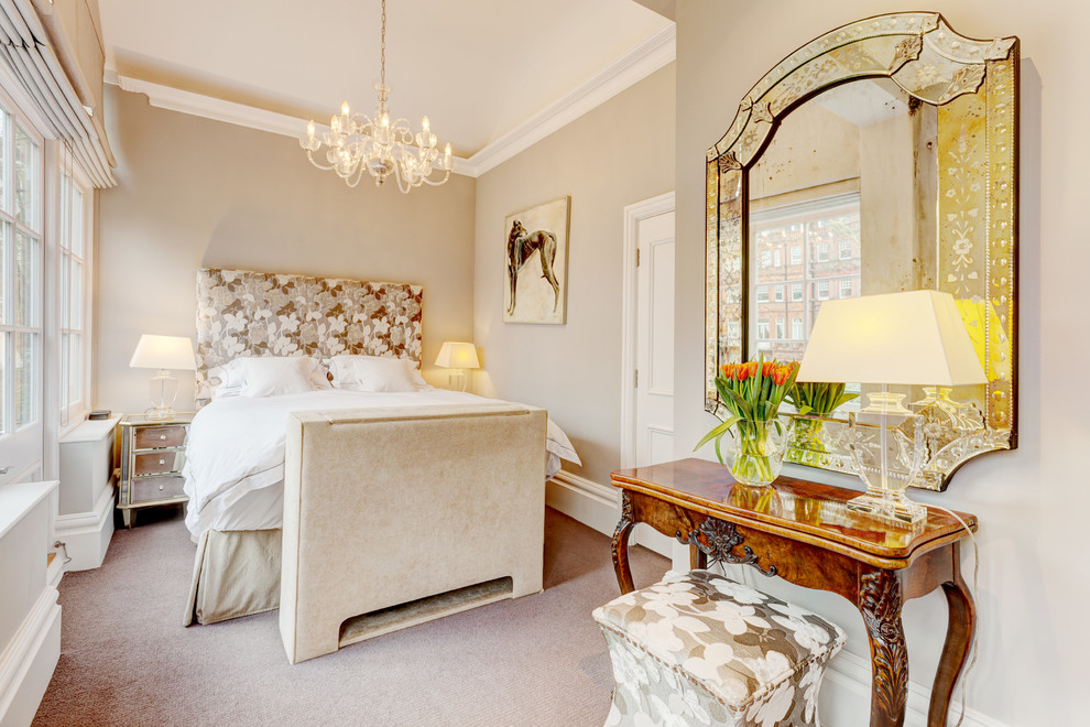 This is an example of a traditional bedroom in London with beige walls, carpet and no fireplace.