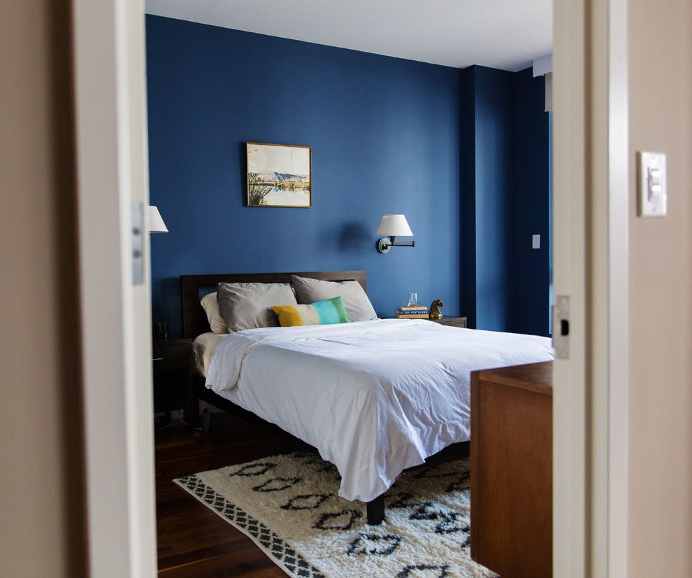 Exemple d'une chambre parentale rétro de taille moyenne avec un mur bleu, parquet foncé et aucune cheminée.