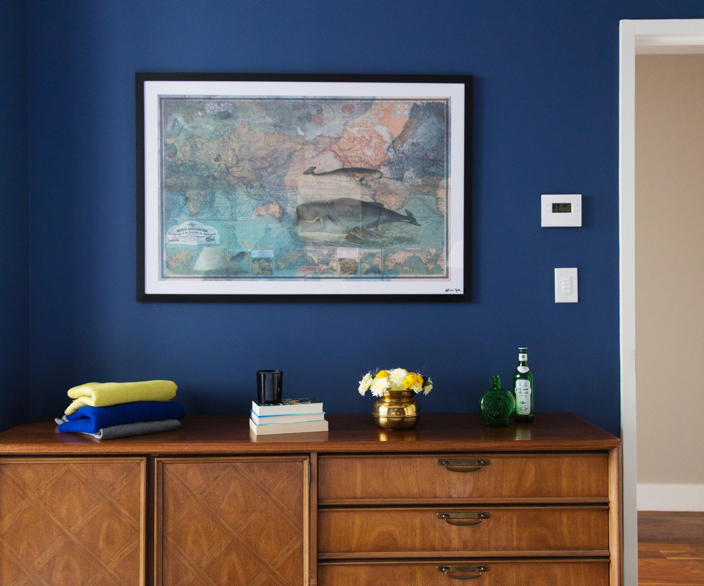 Réalisation d'une chambre parentale vintage de taille moyenne avec un mur bleu et parquet foncé.