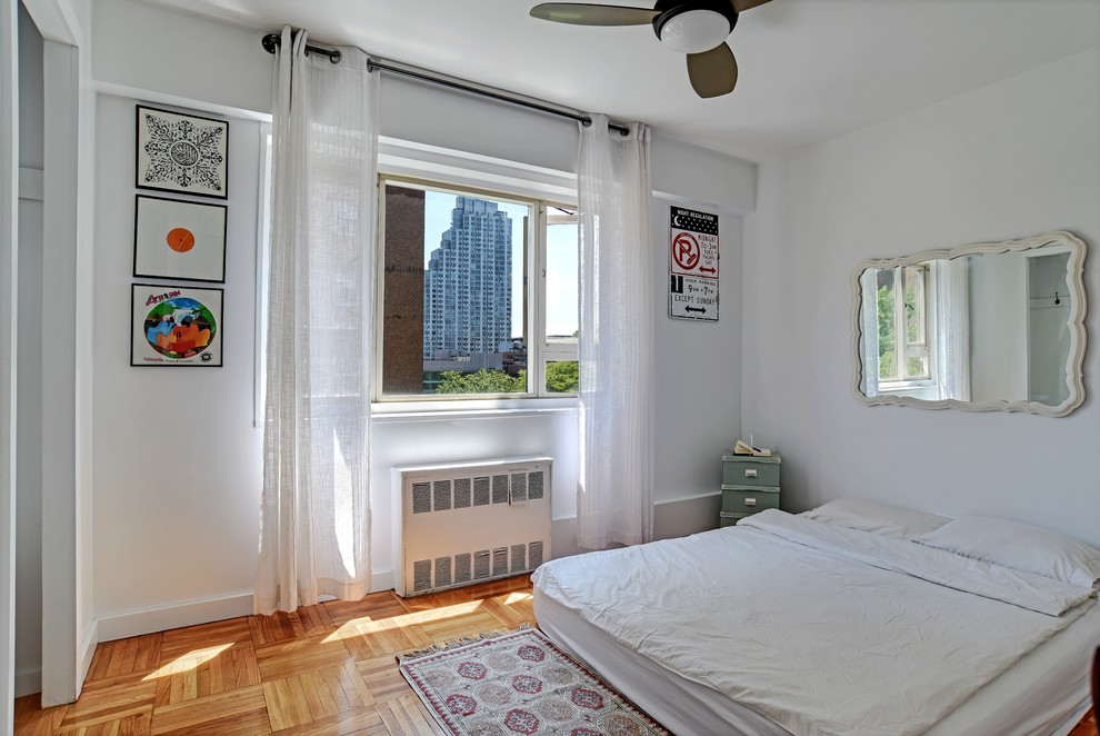 Ejemplo de dormitorio tradicional renovado pequeño con paredes blancas, suelo de madera en tonos medios y suelo marrón