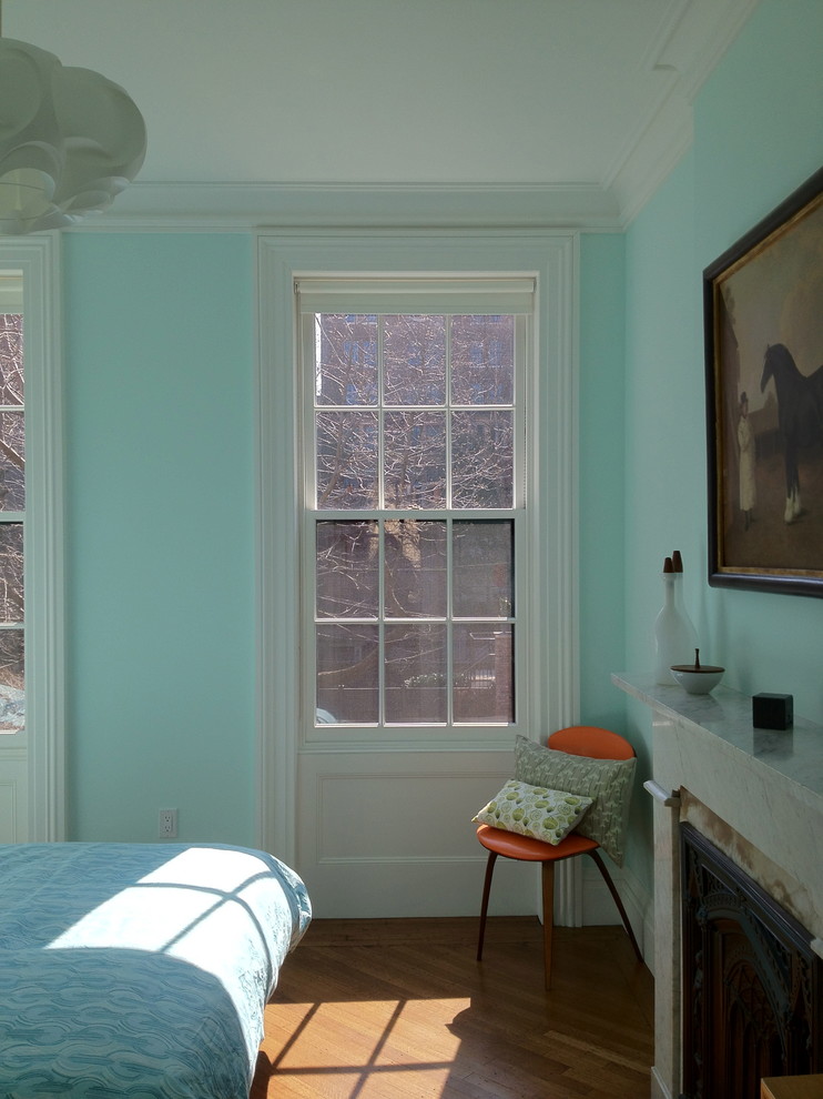 Imagen de dormitorio principal clásico renovado de tamaño medio con paredes azules, suelo de madera en tonos medios, todas las chimeneas y marco de chimenea de piedra