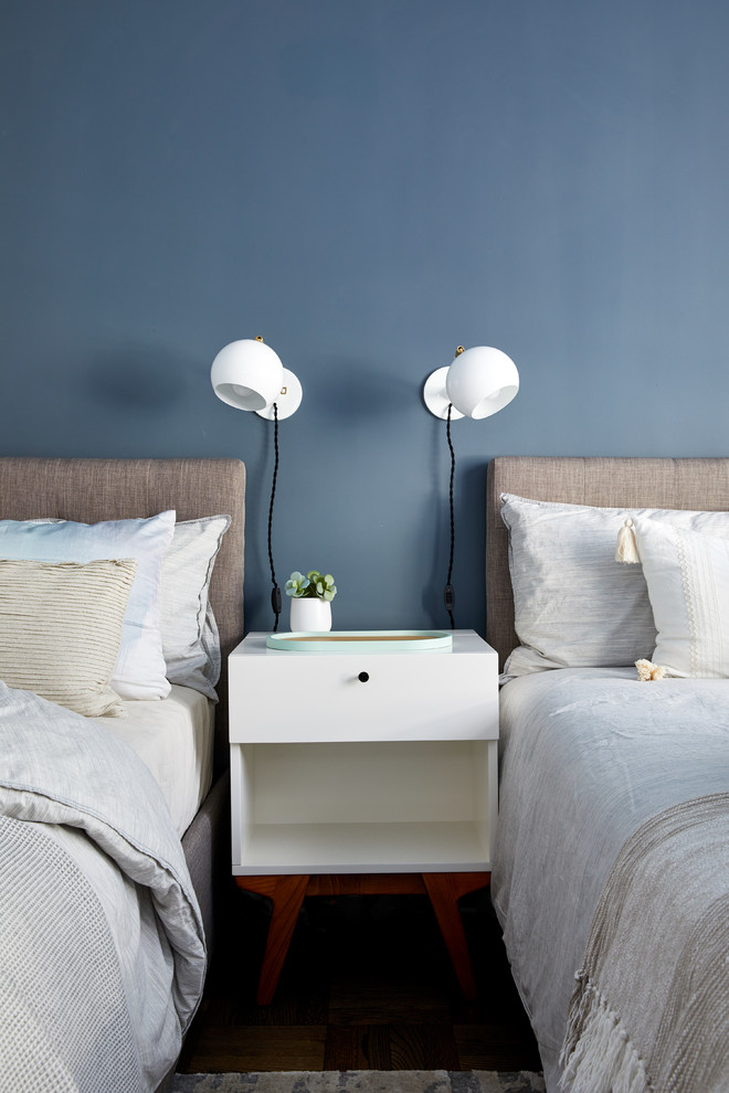 Cette image montre une chambre design avec un mur bleu, un sol en bois brun et un sol marron.