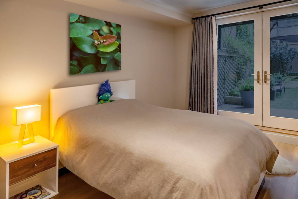 Medium sized contemporary bedroom in New York with light hardwood flooring.