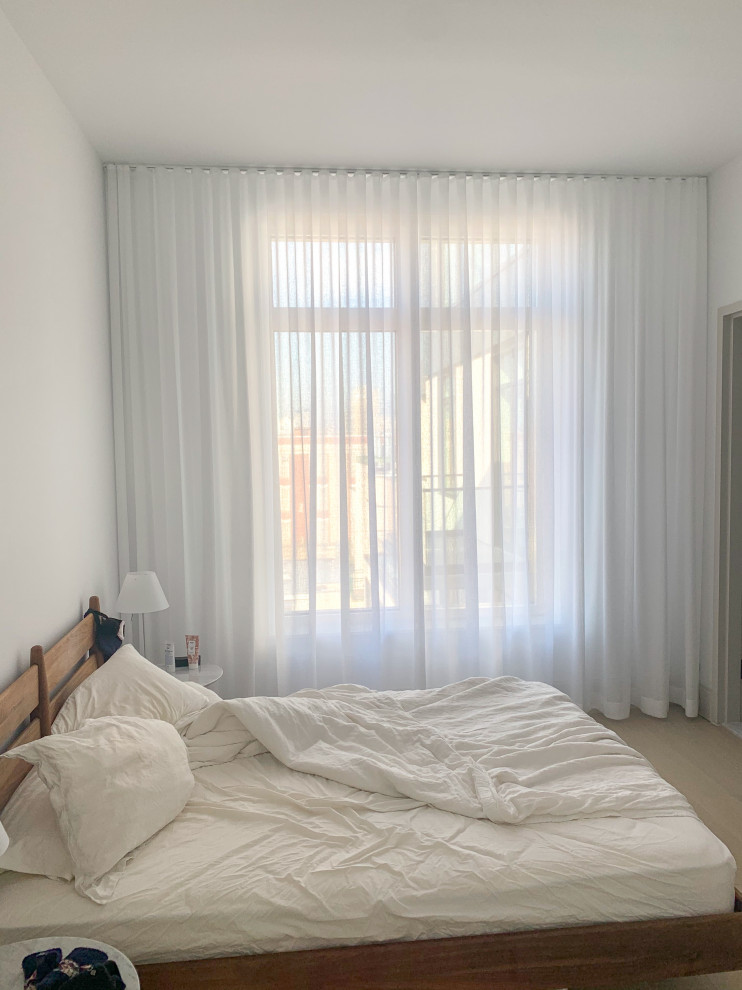 Inspiration pour une petite chambre parentale minimaliste avec un mur blanc, parquet clair et un sol beige.