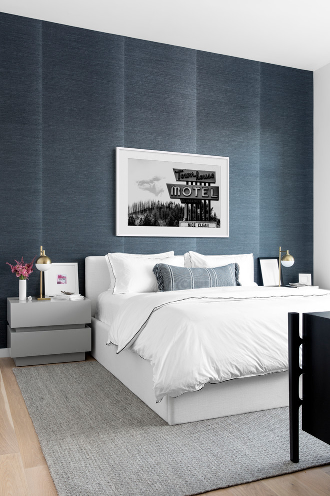 Inspiration for a contemporary bedroom in New York with blue walls, light hardwood flooring and beige floors.