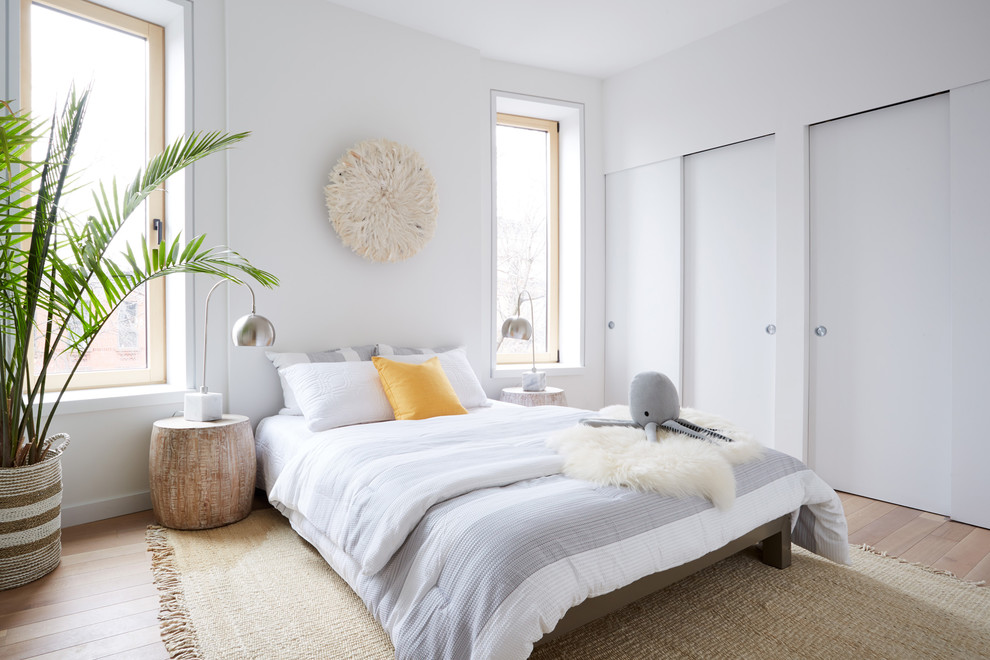 Medium sized scandi master bedroom in New York with white walls, dark hardwood flooring and brown floors.