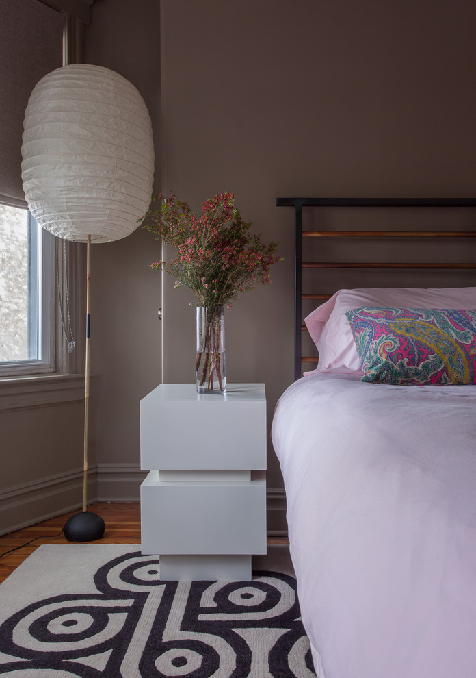 Idée de décoration pour une chambre parentale grise et rose design de taille moyenne avec un mur marron et parquet clair.
