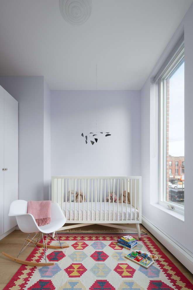 Ispirazione per una piccola camera degli ospiti design con pareti viola, parquet chiaro e pavimento marrone