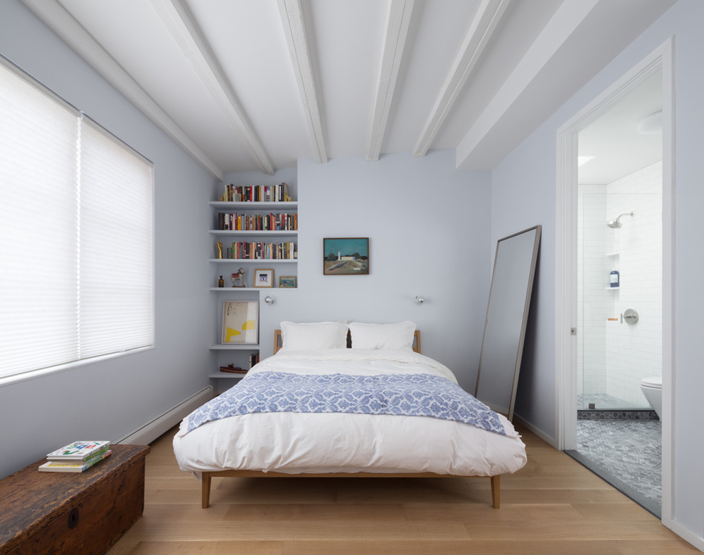 Réalisation d'une petite chambre parentale design avec un mur bleu, parquet clair et un sol marron.