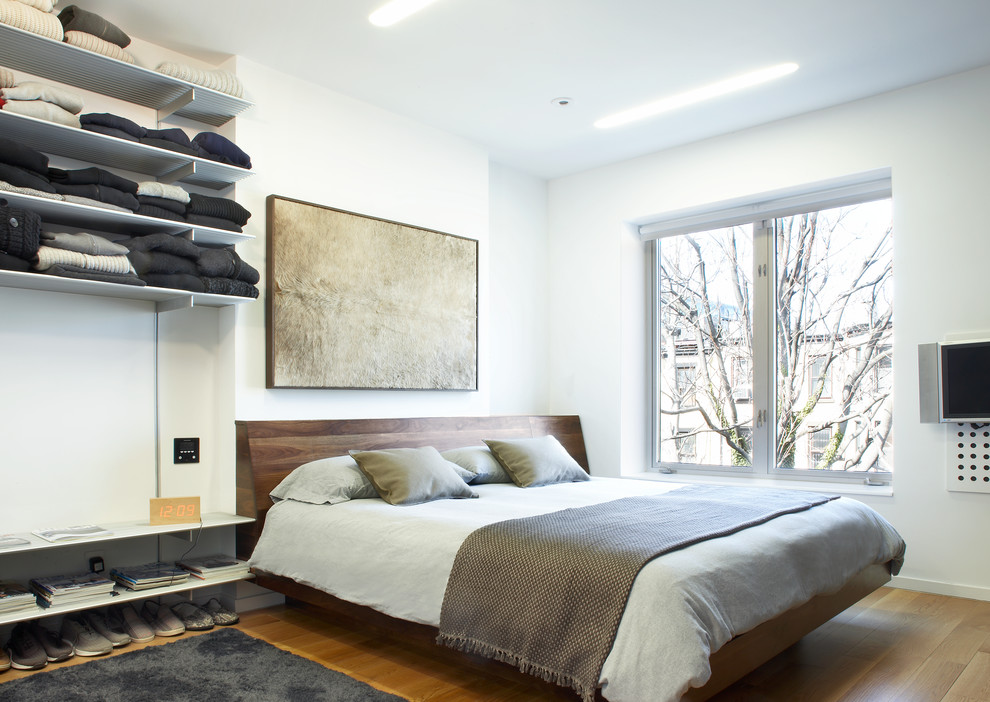 Стильный дизайн: спальня среднего размера в современном стиле с белыми стенами, паркетным полом среднего тона и коричневым полом - последний тренд