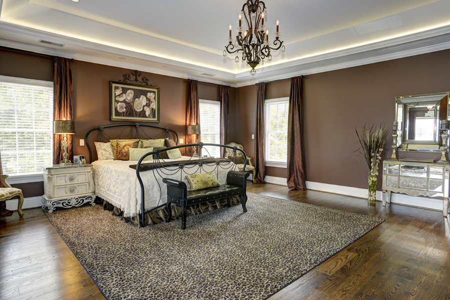 Foto di una grande camera matrimoniale chic con pareti marroni, pavimento in legno massello medio e pavimento marrone