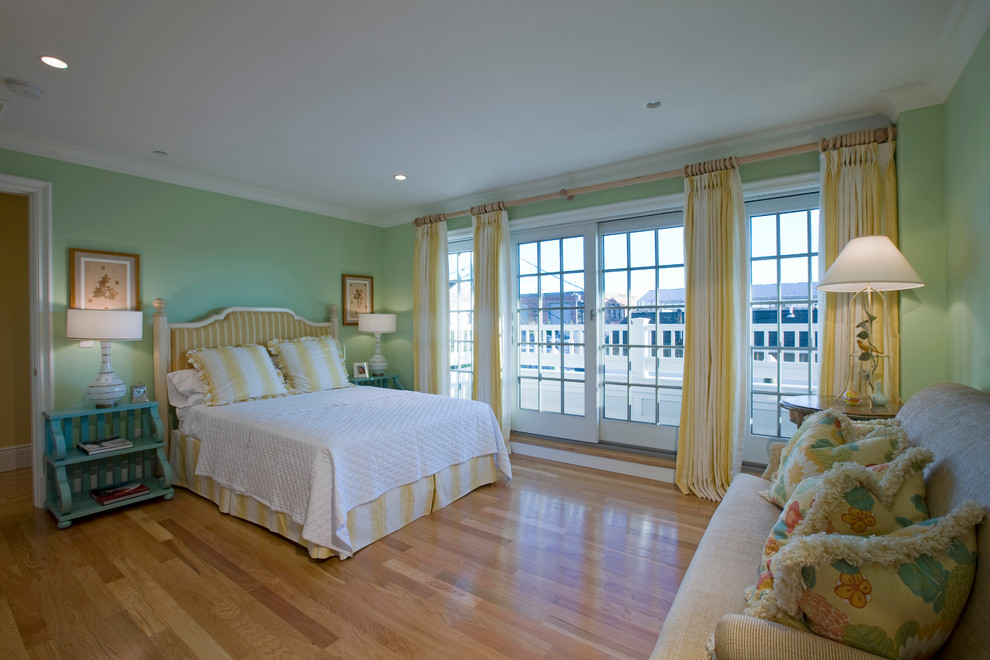 Medium sized beach style master bedroom in New York with green walls and light hardwood flooring.