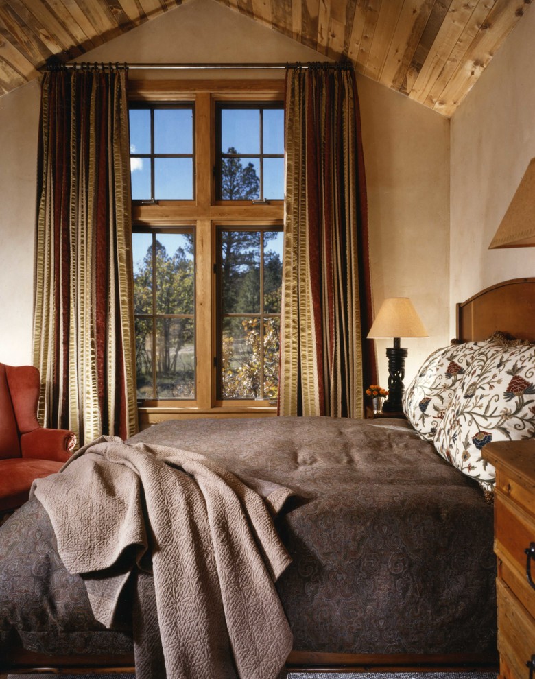 Imagen de dormitorio principal rural de tamaño medio sin chimenea con paredes beige, suelo de madera oscura y suelo marrón
