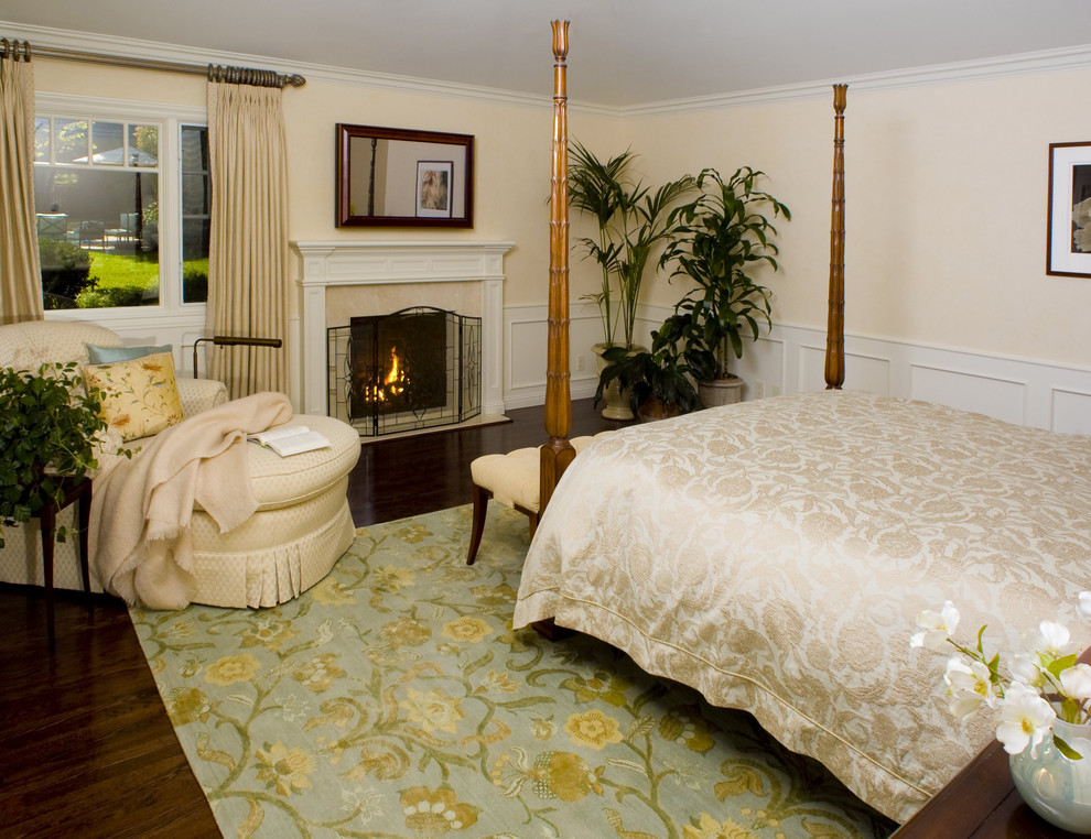 Elegant dark wood floor bedroom photo in San Francisco with beige walls and a standard fireplace