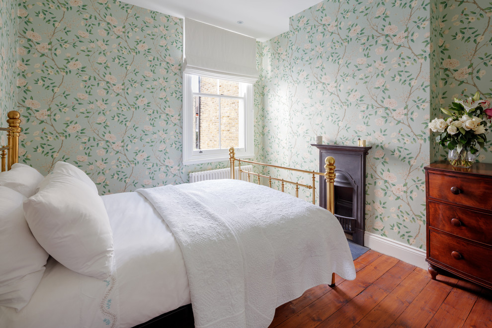 Imagen de habitación de invitados tradicional grande con paredes verdes, suelo de madera en tonos medios, todas las chimeneas y suelo marrón