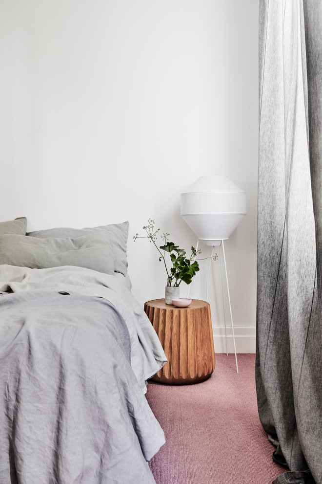 Diseño de dormitorio principal moderno de tamaño medio sin chimenea con paredes blancas, moqueta y suelo rosa