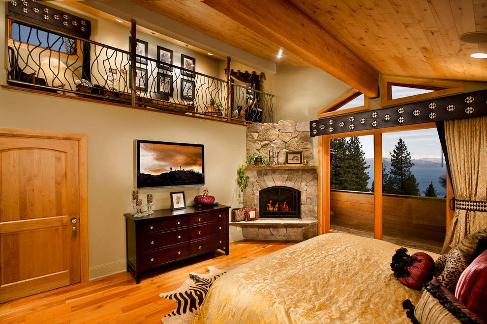На фото: спальня в стиле неоклассика (современная классика) с угловым камином и телевизором с