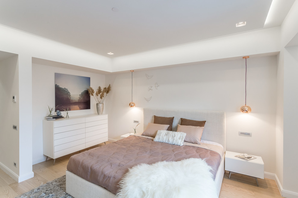 This is an example of a medium sized contemporary master and grey and pink bedroom in Manchester with white walls, light hardwood flooring and beige floors.