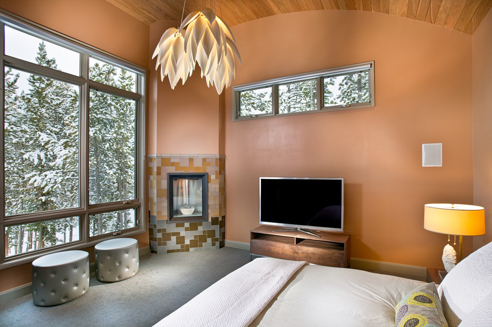 Идея дизайна: большая хозяйская спальня в современном стиле с угловым камином, фасадом камина из плитки, ковровым покрытием, коричневыми стенами и серым полом