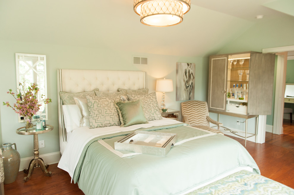 Modelo de habitación de invitados tradicional renovada de tamaño medio sin chimenea con paredes verdes y suelo de madera en tonos medios