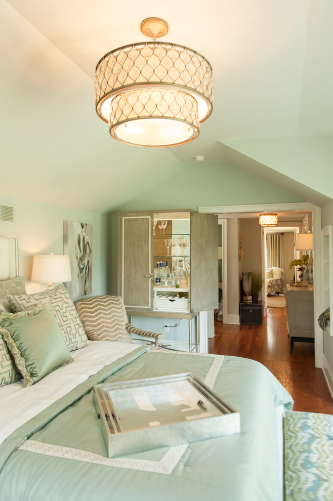 Modelo de habitación de invitados clásica renovada de tamaño medio sin chimenea con paredes verdes y suelo de madera en tonos medios
