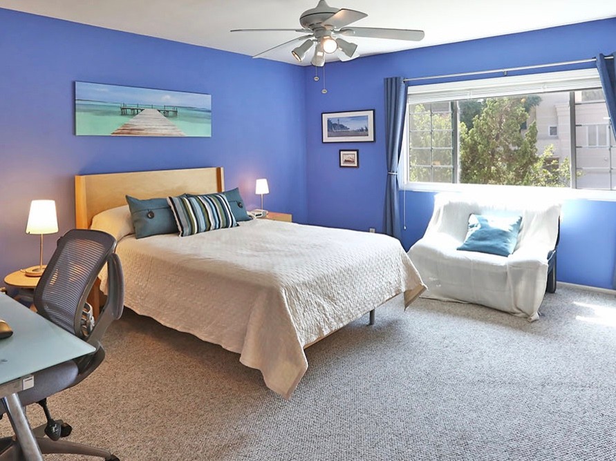 На фото: хозяйская спальня среднего размера в стиле ретро с фиолетовыми стенами и ковровым покрытием без камина