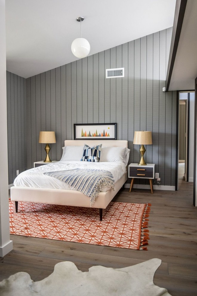 Imagen de habitación de invitados actual de tamaño medio sin chimenea con paredes grises, suelo de madera oscura y suelo marrón