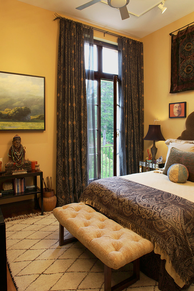 Immagine di una piccola camera matrimoniale boho chic con pareti gialle e pavimento in legno massello medio