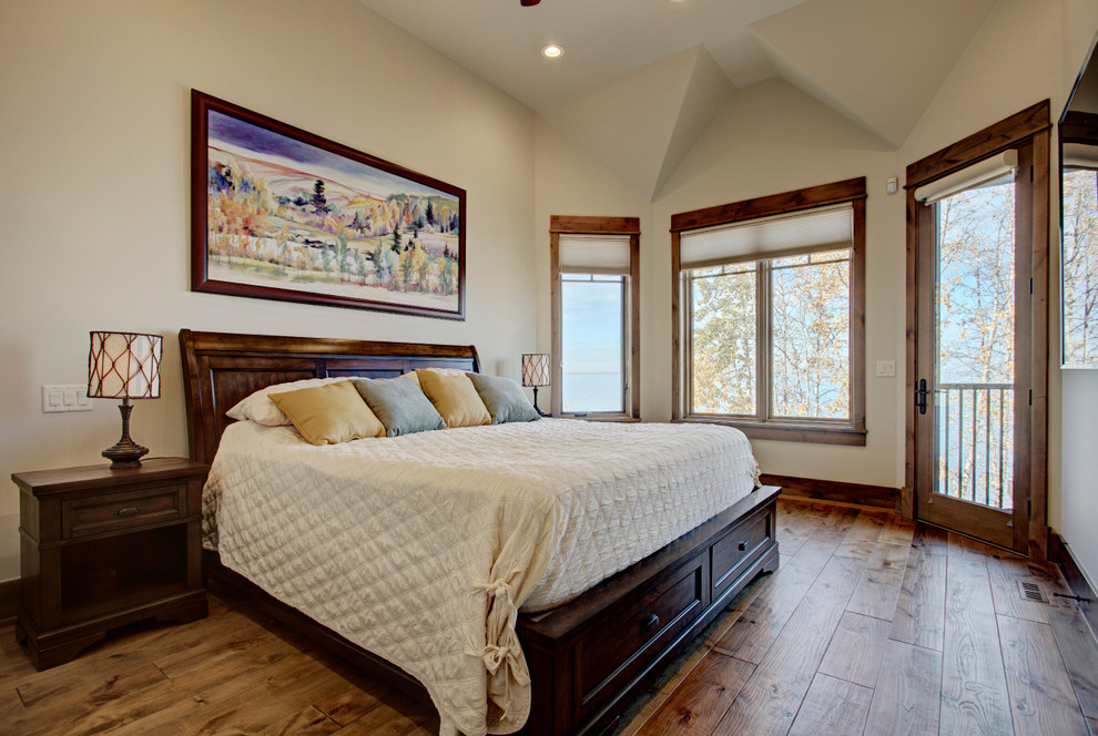 Modelo de dormitorio principal rústico de tamaño medio sin chimenea con paredes beige, suelo de madera oscura y suelo marrón