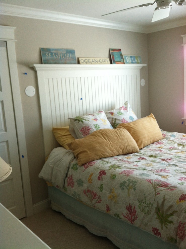 Imagen de habitación de invitados costera con paredes beige, moqueta y suelo beige