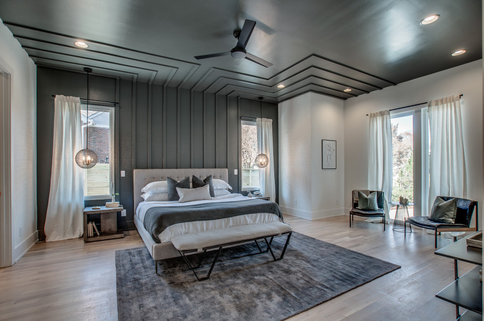 Diseño de dormitorio contemporáneo con paredes grises, suelo de madera en tonos medios, suelo marrón y panelado