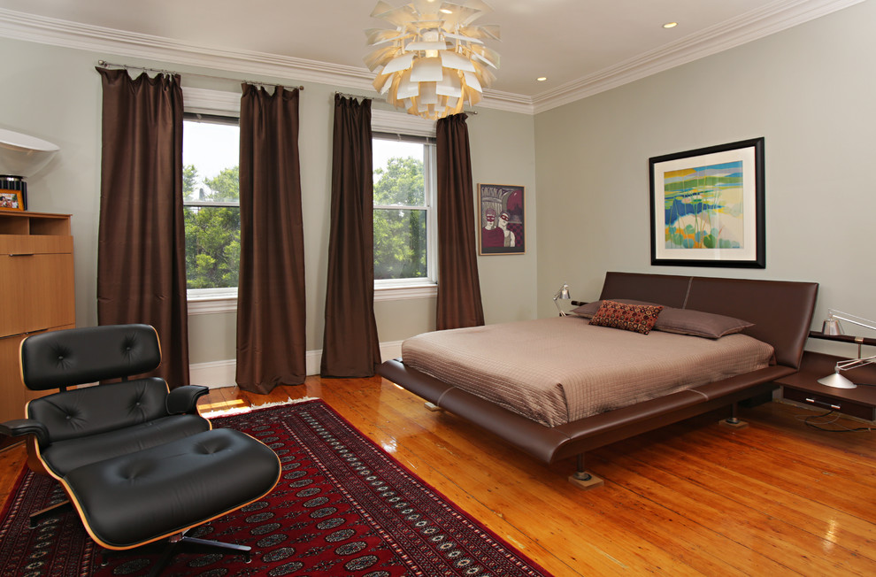 Aménagement d'une chambre contemporaine avec un mur gris, un sol en bois brun et aucune cheminée.
