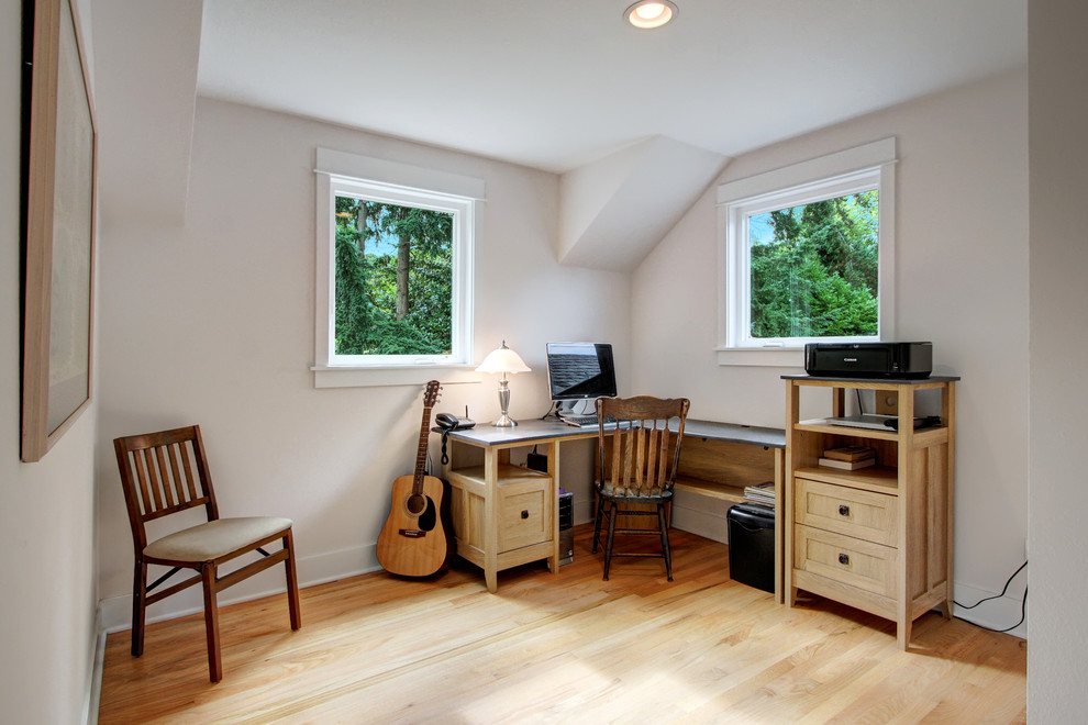 Ejemplo de habitación de invitados de estilo americano pequeña con paredes blancas y suelo de madera clara