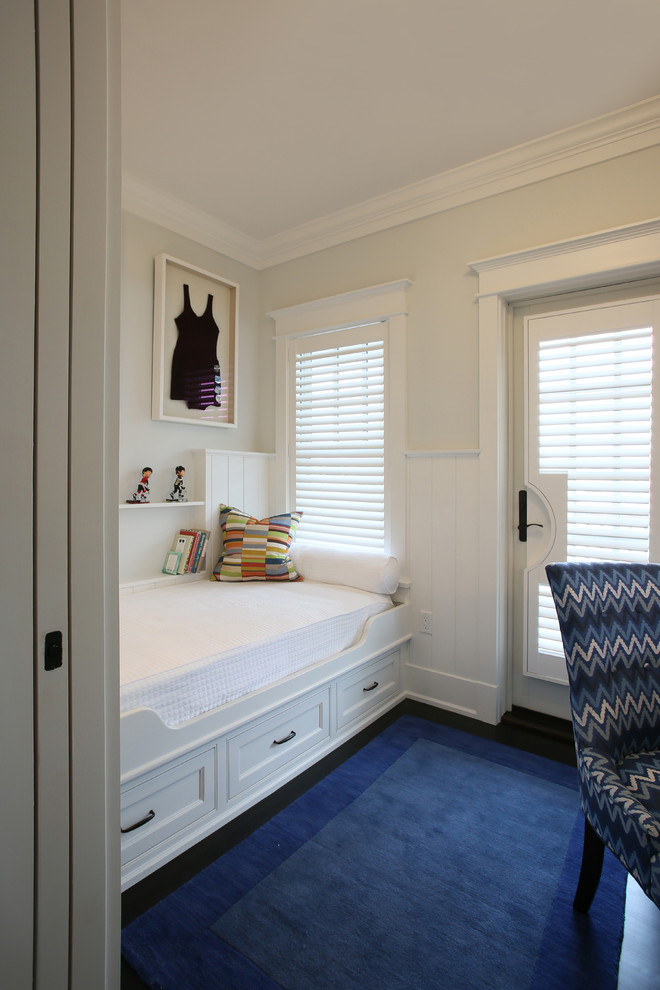 Cette image montre une petite chambre d'amis marine avec un mur blanc et parquet foncé.