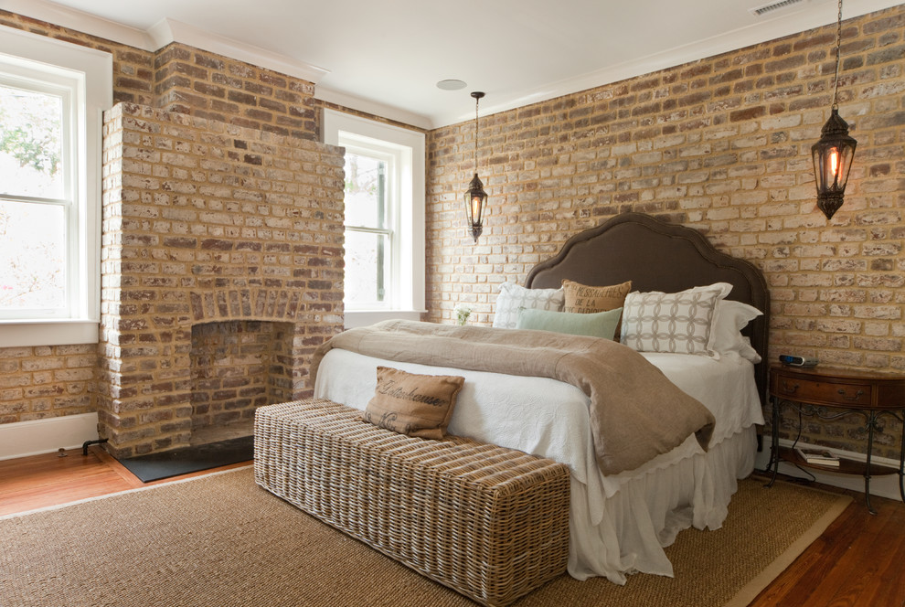 На фото: спальня в классическом стиле с фасадом камина из кирпича