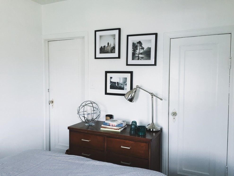 Ejemplo de habitación de invitados bohemia pequeña con paredes blancas y suelo de madera clara