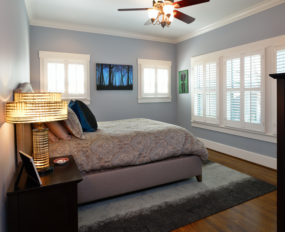Immagine di una camera matrimoniale american style di medie dimensioni con pareti blu, pavimento in legno massello medio e nessun camino