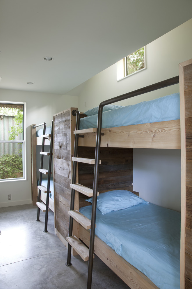 This is an example of a modern bedroom in Austin with concrete flooring.